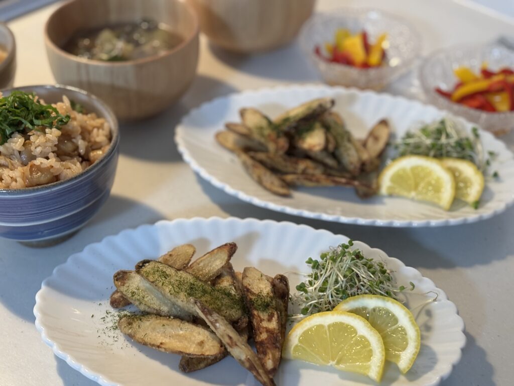 ごぼうの唐揚げとスプラウト、レモンを盛り付けた白い皿。食卓の副菜としての和風メニューの全体像。