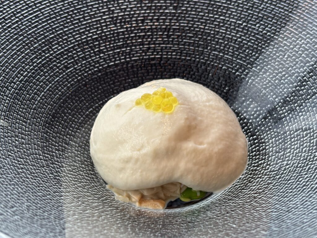 フォアグラの茶碗蒸し風「TENQOOの前菜、フォアグラを使った茶碗蒸し風の料理。クリーミーな泡の上に黄色い粒状ソースが添えられている。」