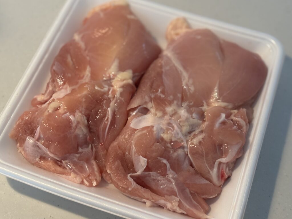 生肉の写真。下処理前の鶏もも肉がパックに入っている様子。