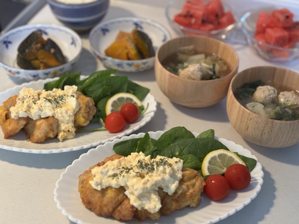 盛り付け写真③タルタルソースをたっぷりかけたチキン南蛮と、汁物、副菜、デザートが写った写真。彩りが良い食卓。