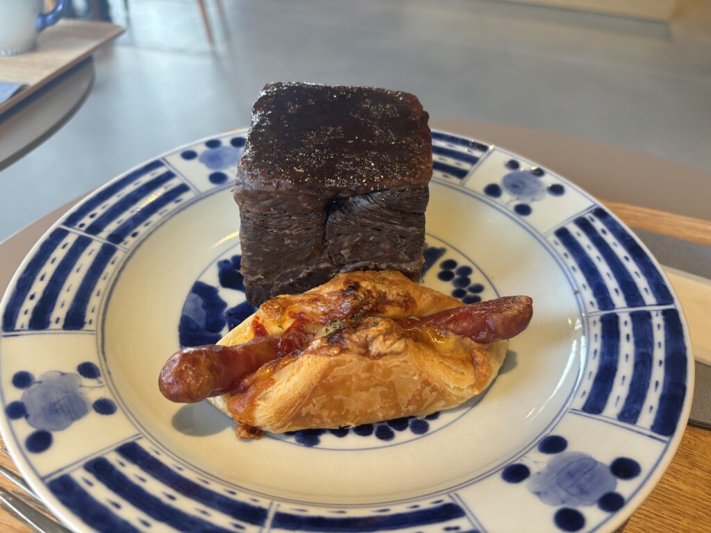 有田焼のプレートにのった有田豚のチーズウインナーデニッシュ。パリッとしたデニッシュ生地とジューシーなウインナーが映える一皿