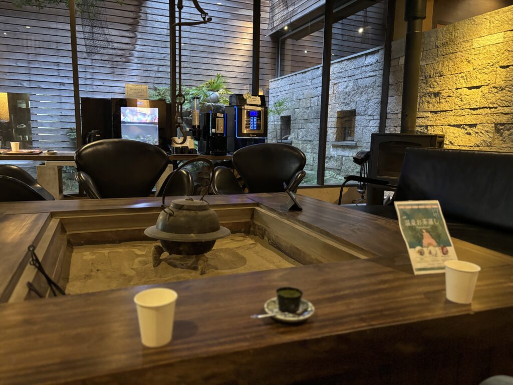 ドリンクコーナーのあるラウンジ。吉田屋ラウンジのドリンクコーナー。コーヒーマシンと黒革チェアが並ぶ静かな休憩スペース。
