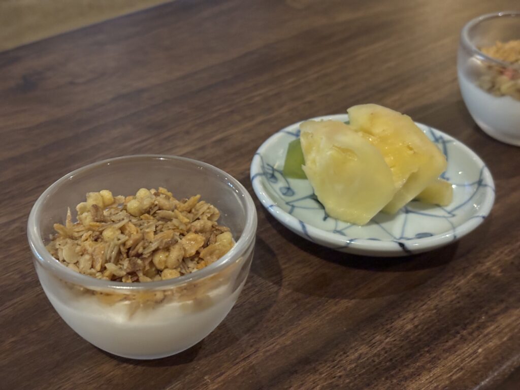 ヨーグルトとカットフルーツの盛り合わせ。吉田屋の朝サービス。グラノーラ入りヨーグルトとパインの小皿盛り合わせで、朝にぴったりの軽いデザート。
