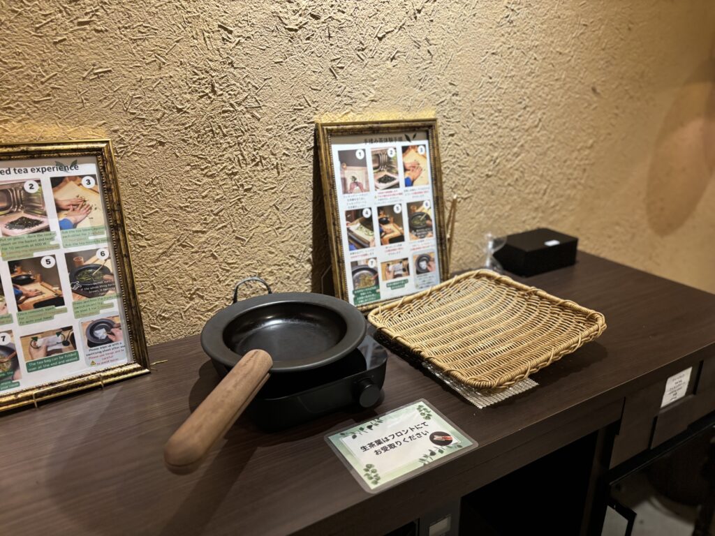 煎じ茶体験の道具（フライパンと籠）。吉田屋の嬉野煎じ茶体験で使用する道具。小鍋や籠、手順案内が並ぶ体験用カウンター。①