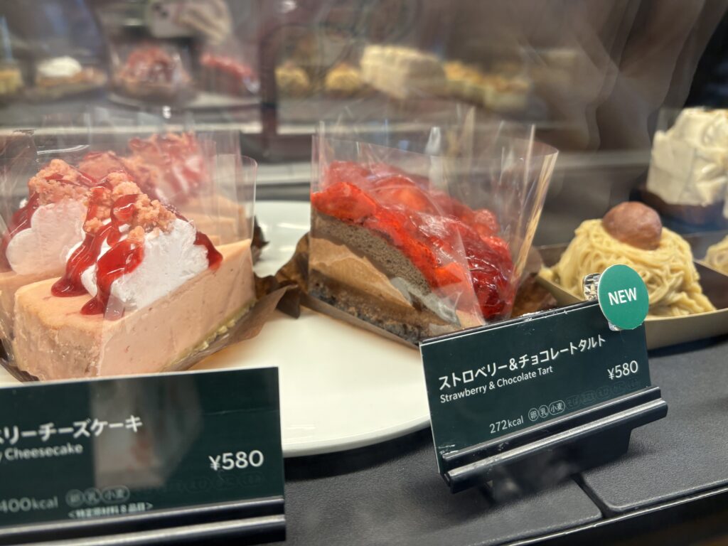 スターバックスのショーケースに並ぶストロベリー＆チョコレートタルト。鮮やかな赤いストロベリーが印象的な写真。