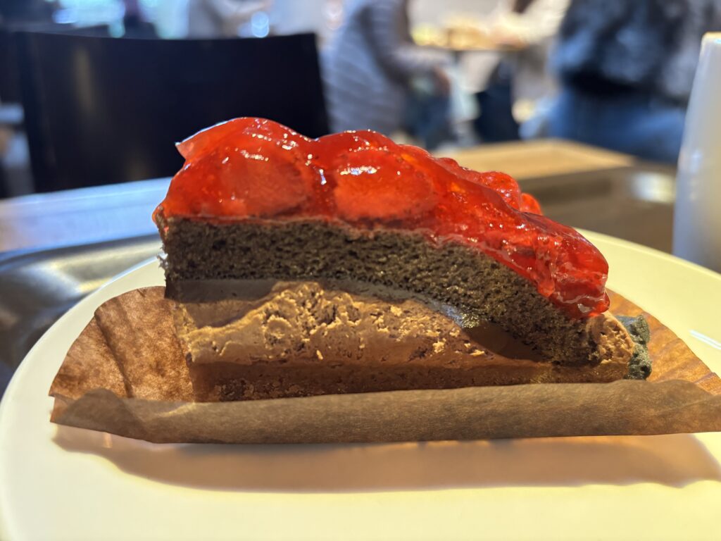 ストロベリー＆チョコレートタルトの断面。チョコレートムースと生地の層に、ストロベリーソースが重なる。