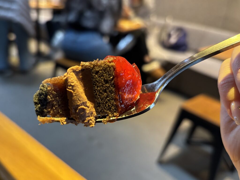 ストロベリー＆チョコレートタルトをスプーンですくった一口の写真。スプーンですくったストロベリー＆チョコレートタルト。チョコレート生地とストロベリーの層が分かる一口サイズ。